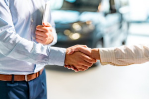 Car dealer shaking hands with a client.